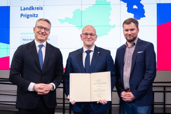 Bei der Übergabe des Fördermittelbescheids (v.l.n.r.): Karsten Wildberger, Bundesminister für Digitales und Staatsmodernisierung, Landrat Christian Müller und Philipp Staskowiak, Sachbearbeiter Projektmanagement/Breitbandausbau in der Kreisverwaltung Prignitz. Foto: @BMDV/Woithe